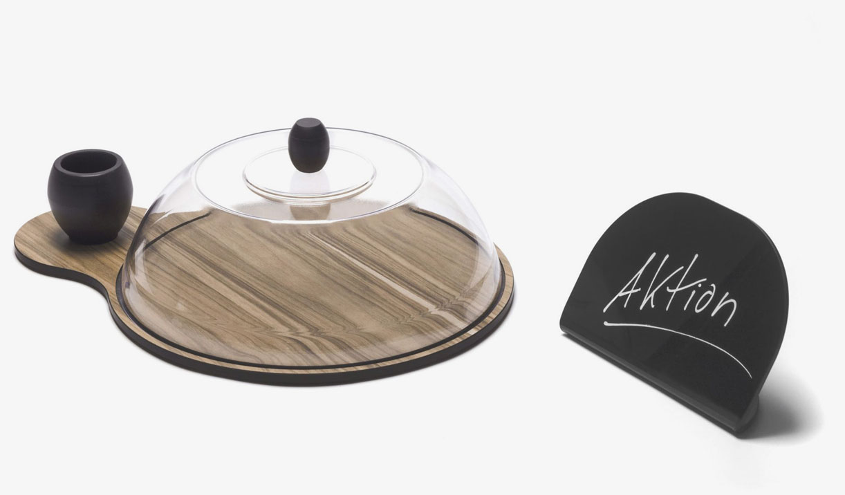 Holzplatte mit Glasdeckel und Schild ‚Aktion‘ Holzplatte mit Glasdeckel, kleiner Schale und Schild ‚Aktion‘ zur Lebensmittelpräsentation